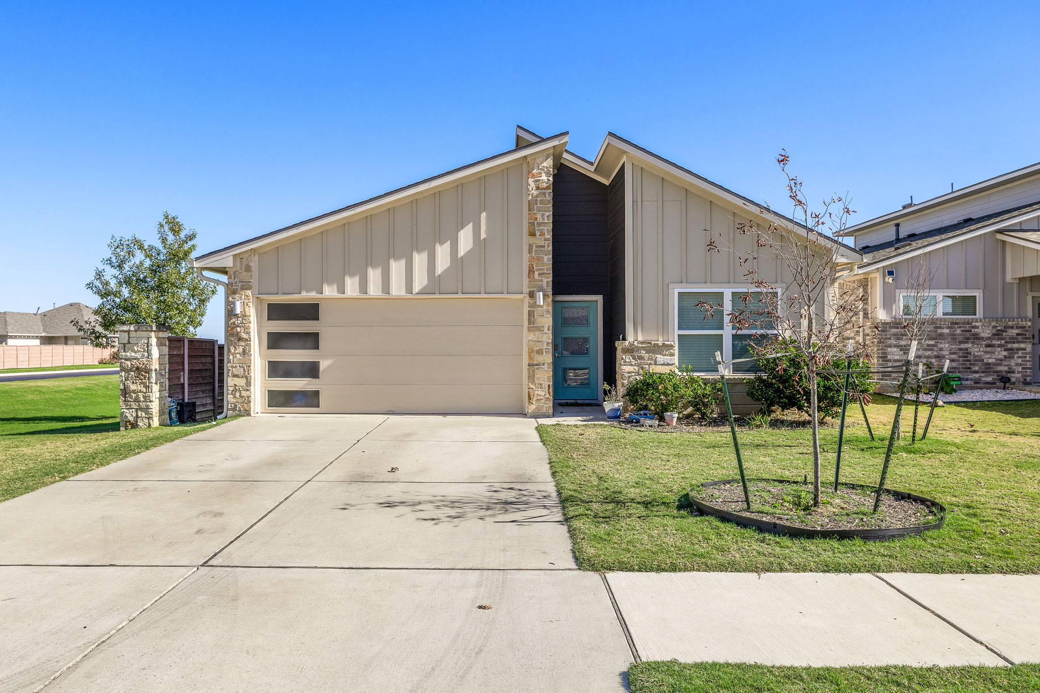 5001 Vanner Path Georgetown, TX 78626 - Photo 1 of 1 Mid-century inspired home featuring board and batten siding, stone siding, concrete driveway, and a garage