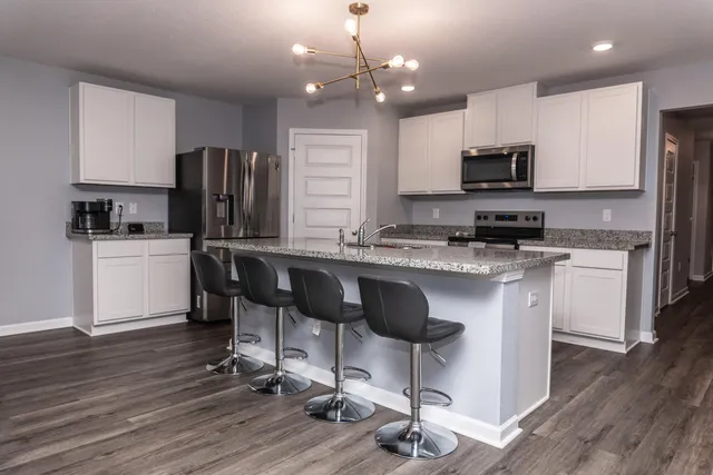 a kitchen with stainless steel appliances granite countertop a sink refrigerator and cabinets