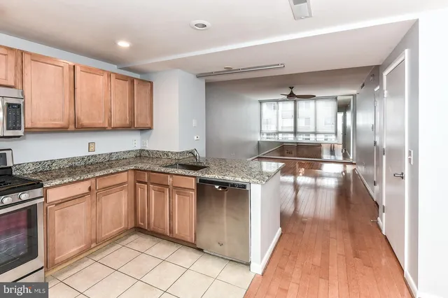 a kitchen with granite countertop a stove a sink and a refrigerator