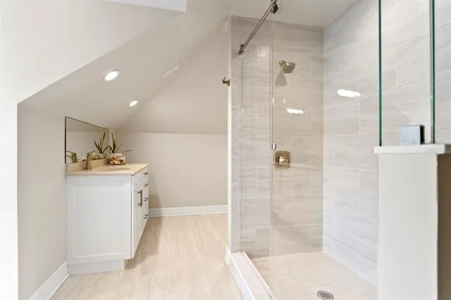 a bathroom with a shower sink and mirror