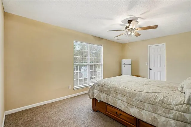 a bedroom with a bed chandelier and a window