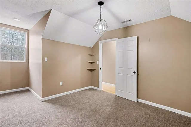a view of a big room with windows and chandelier fan