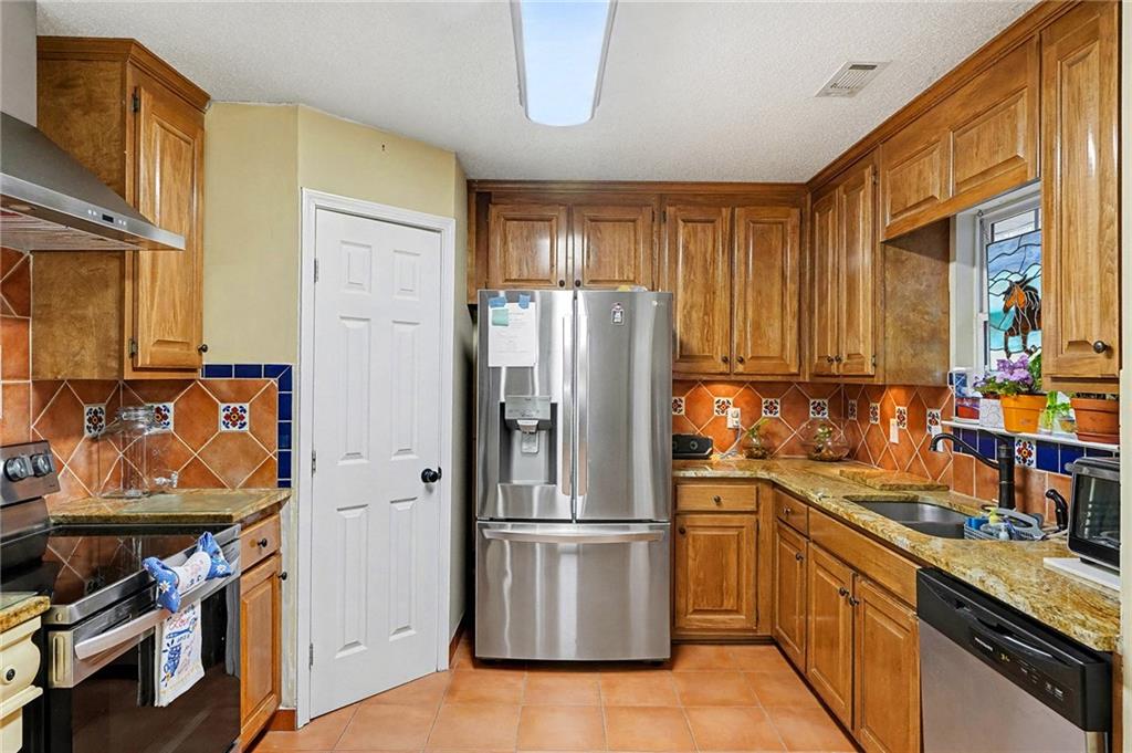 235 Cecil Jackson Road Griffin, GA 30223 - Photo 9 of 34 a kitchen with stainless steel appliances granite countertop a refrigerator stove and sink