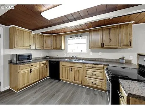 a kitchen with granite countertop wooden cabinets a sink and dishwasher
