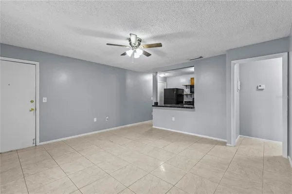 a view of an empty room with a ceiling fan and window