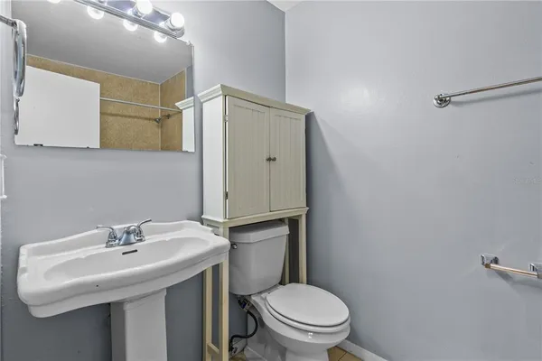 a bathroom with a sink toilet and a mirror