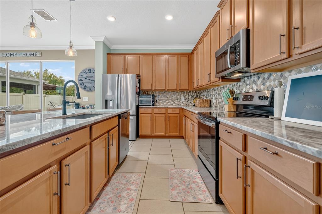 2899 Parkfield Road St. Cloud, FL 34772 - Photo 14 of 52 a kitchen with stainless steel appliances granite countertop a sink and cabinets