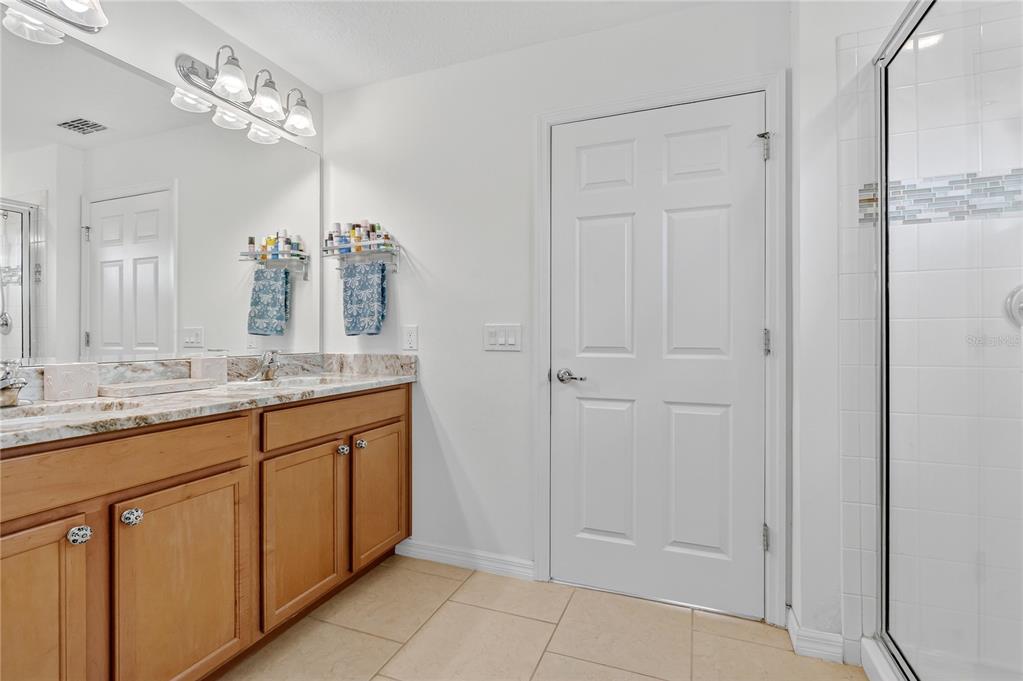 2899 Parkfield Road St. Cloud, FL 34772 - Photo 19 of 52 a bathroom with a granite countertop sink two mirror and a shower