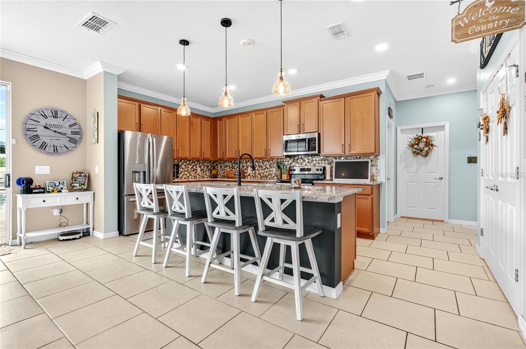2899 Parkfield Road St. Cloud, FL 34772 - Photo 10 of 52 a large kitchen with a table chairs refrigerator and a window