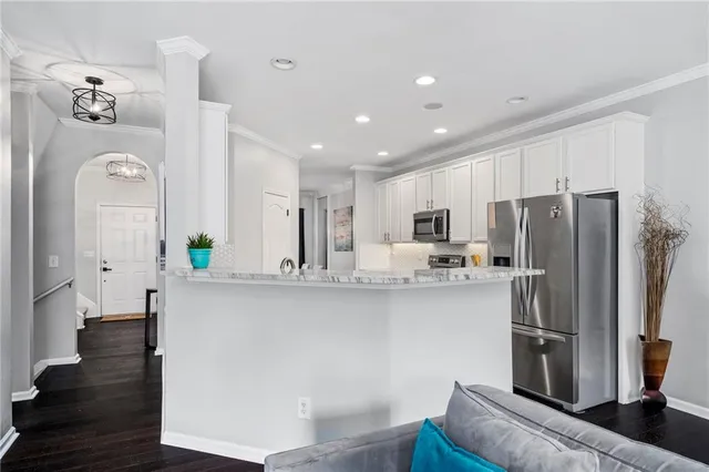 a kitchen with stainless steel appliances granite countertop a refrigerator a stove and a sink