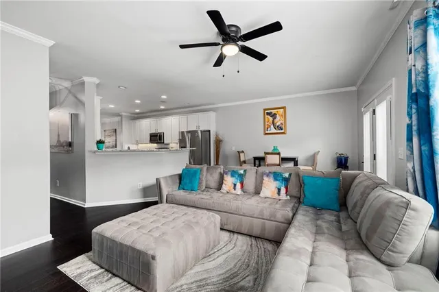 a living room with furniture and a view of kitchen