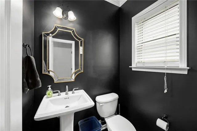 a bathroom with a toilet sink and mirror