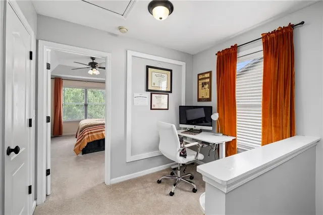 a view of a workspace with furniture and a window