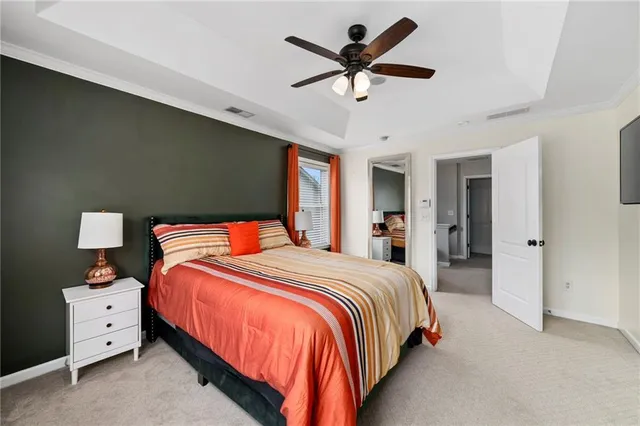 a bedroom with a large bed and a chandelier fan