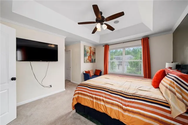 a bedroom with a bed a flat screen tv and a large window