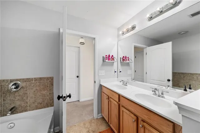 a bathroom with a tub sink and mirror