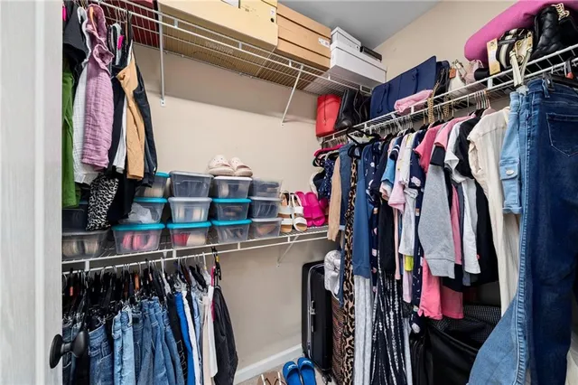 a view of walk in closet with clothes