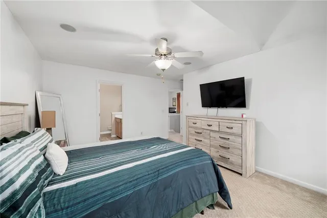 a bedroom with a bed a flat tv screen and a chandelier