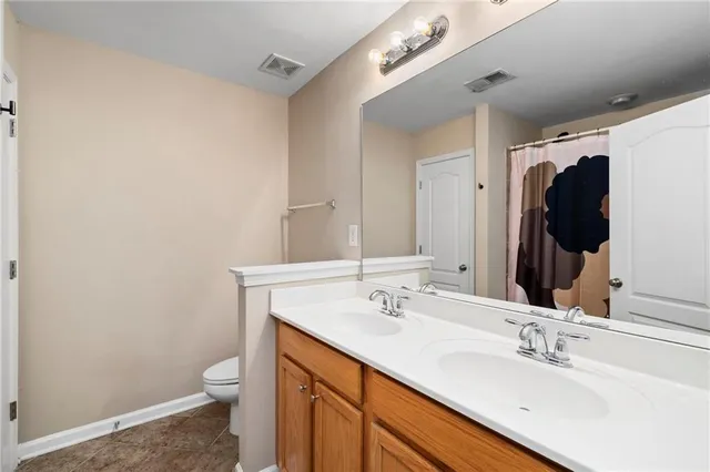 a bathroom with a sink vanity granite and toilet