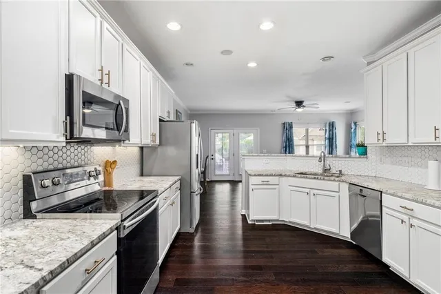 a kitchen with stainless steel appliances granite countertop a sink stove microwave and cabinets