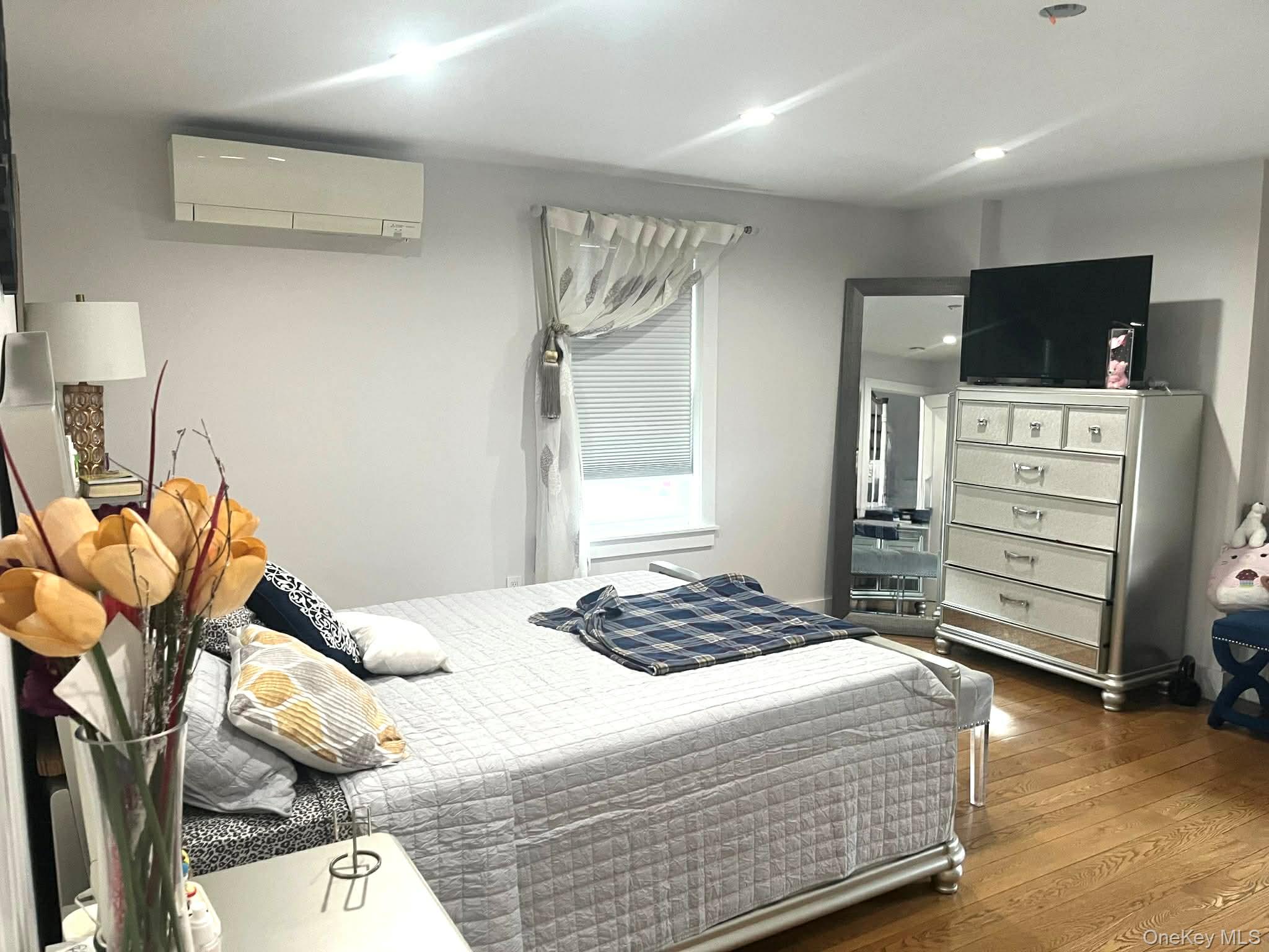 27-15 Butler Street Queens, NY 11369 - Photo 3 of 18 a bedroom with a bed and flat screen tv