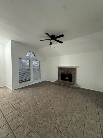 an empty room with fireplace and fan