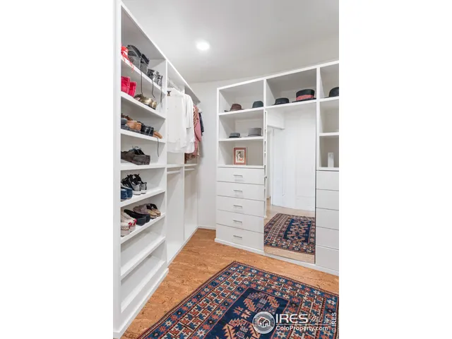 a view of walk in closet with clothes and shoes
