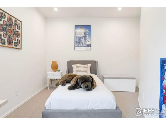 a bedroom with a bed and a painting on the wall