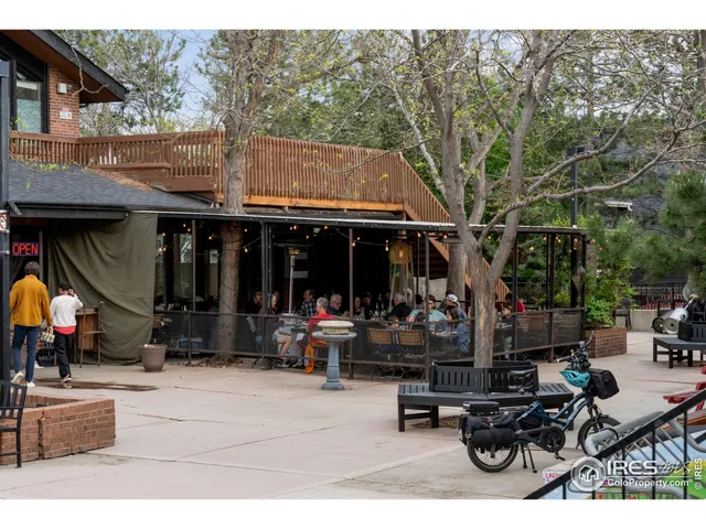a view of the patio with dining table and chairs under an umbrella