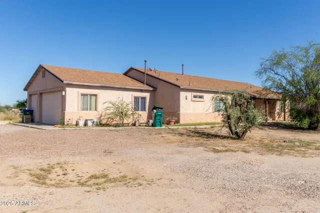 a front view of a house with yard and tress in the background