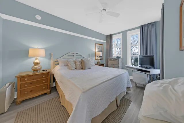 a bedroom with bed a flat tv screen and a dresser