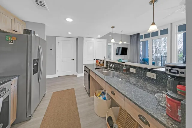 a large kitchen with granite countertop a sink and a refrigerator