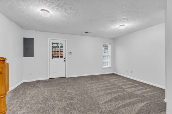 a view of an empty room with a chandelier fan