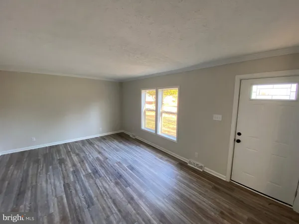 a view of an empty room with wooden floor