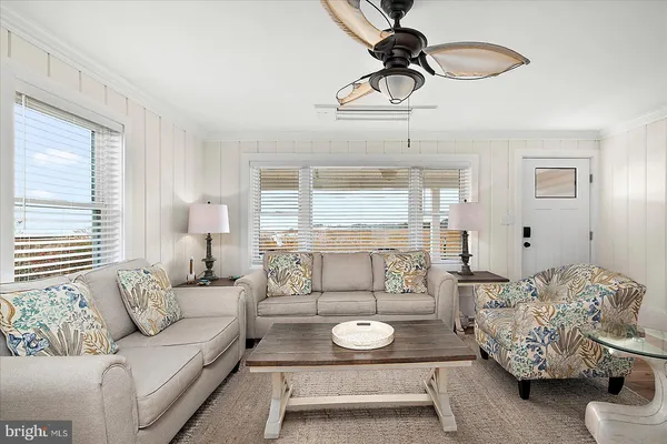 a kitchen with stainless steel appliances granite countertop a refrigerator a stove a sink a dining table and chairs with wooden floor