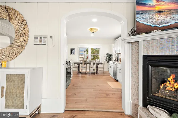 a kitchen with stainless steel appliances a stove top oven a sink a refrigerator white cabinets and wooden floor