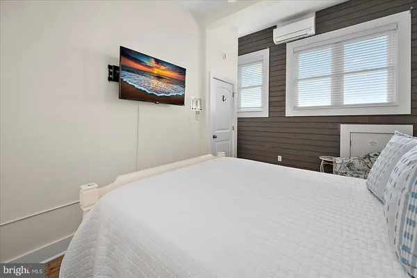 a bedroom with a bed a dresser and window