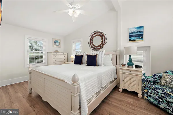 a bedroom with a large bed chandelier and a window