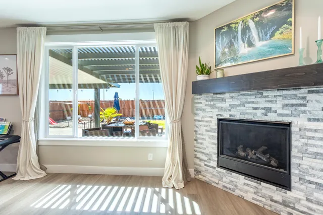 a living room with a fireplace and a floor to ceiling window
