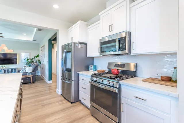 a kitchen with stainless steel appliances a stove microwave and a refrigerator