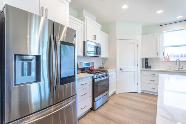 a kitchen with stainless steel appliances a refrigerator stove and sink