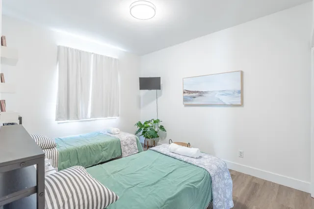 a bedroom with two beds and painting on the wall