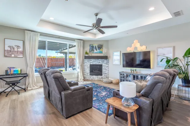 a living room with furniture a flat screen tv and a fireplace