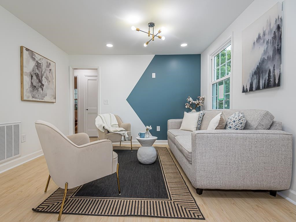 1703 Patton Road Raleigh, NC 27608 - Photo 13 of 30 a living room with furniture a rug and wall paintings