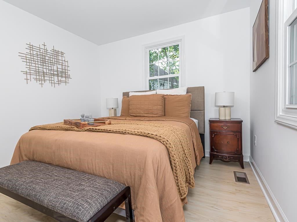 1703 Patton Road Raleigh, NC 27608 - Photo 17 of 30 a bedroom with a bed and windows
