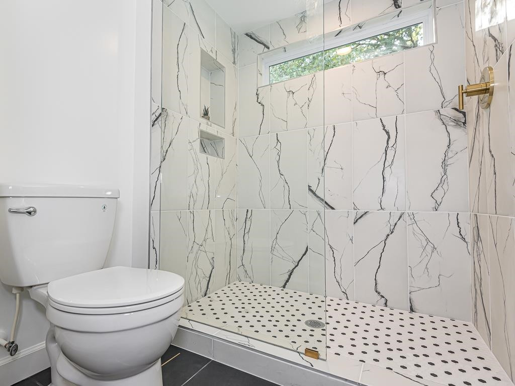 1703 Patton Road Raleigh, NC 27608 - Photo 27 of 30 a bathroom with a toilet and a shower curtain