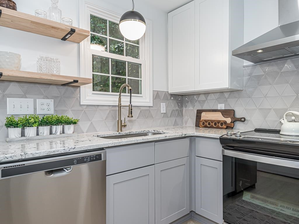 1703 Patton Road Raleigh, NC 27608 - Photo 3 of 30 a kitchen with a sink cabinets window and stainless steel appliances