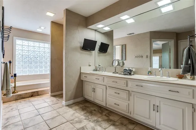 a spacious bathroom with a mirror a sink and a bathtub