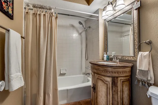 a bathroom with a sink a toilet a mirror and shower