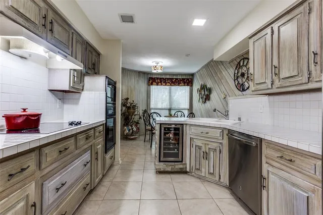 a kitchen with stainless steel appliances granite countertop a sink and dishwasher a stove top oven with wooden floor